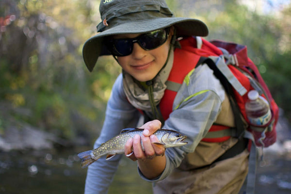 Boy holding a brown trout.