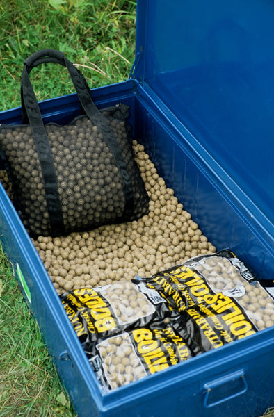 Image of large blue tub full of boilies on grass